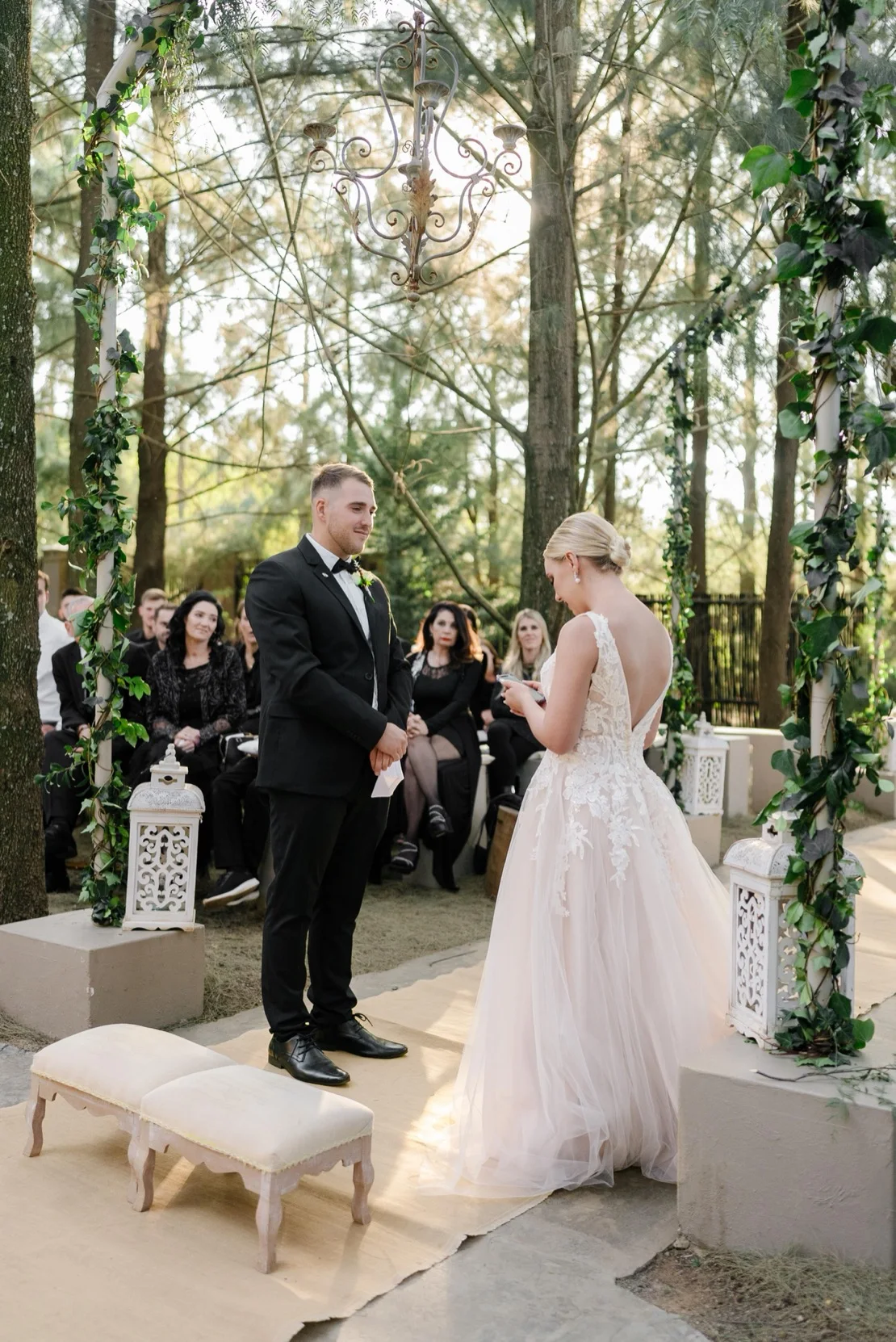 Bride and groom holding hands at the altar under a floral arch, Pretoria wedding
